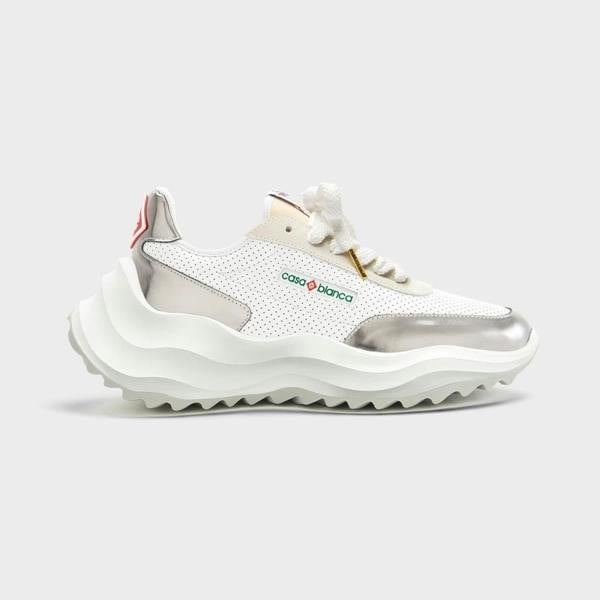Supplied Fashion Atlantis sneaker in white perforated leather with metallic chrome accents and a chunky wavy sole.