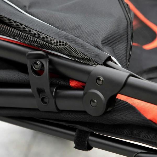 Close-up of folding joint and red fabric trim on a red-and-black pet stroller frame.