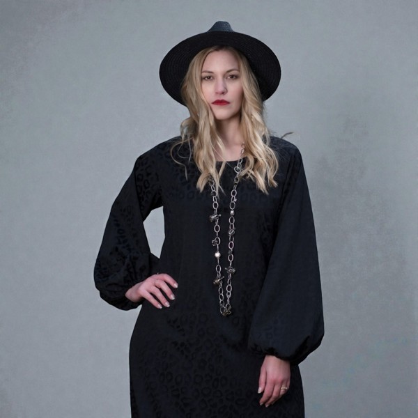 Women's Aphrodite Black Leopard Jacquard Dress, styled with a silver chain necklace and black hat for a chic, coordinated look.