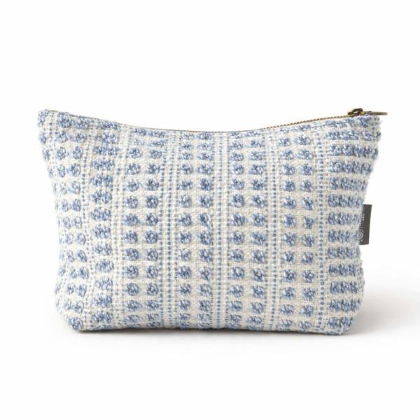 Indigo jacquard toiletry bag with geometric pattern and zip-top closure