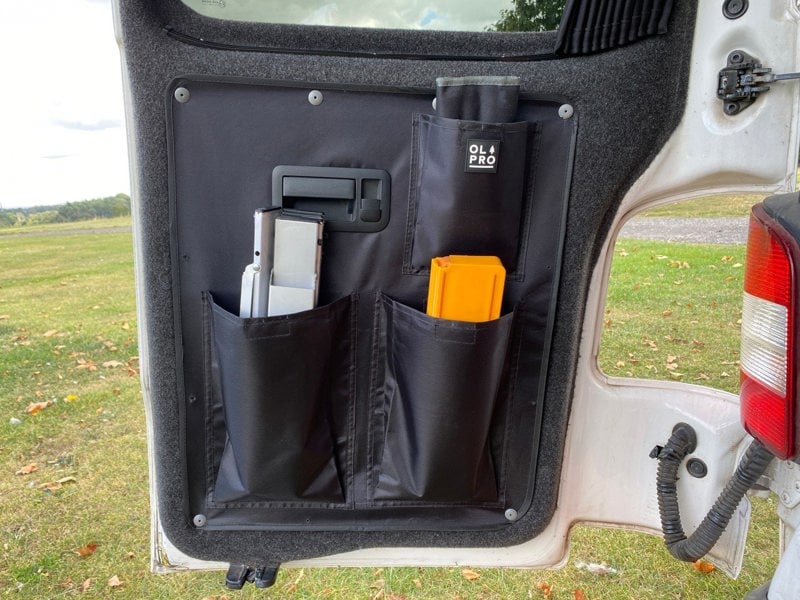 An image of the left hand side of the VW T5/T6 Barn Door Storage Organiser from OLPRO with items stowed inside of it.