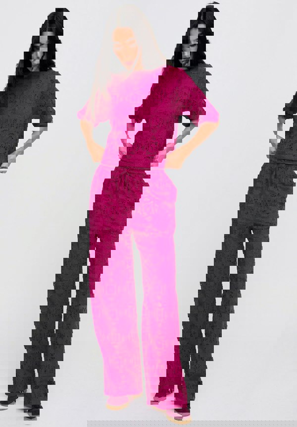 Woman wearing a pink patterned outfit on a white background