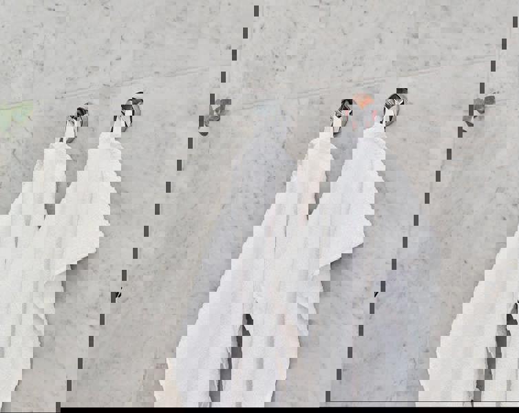 Pair of polished chrome towel hooks on bathroom wall