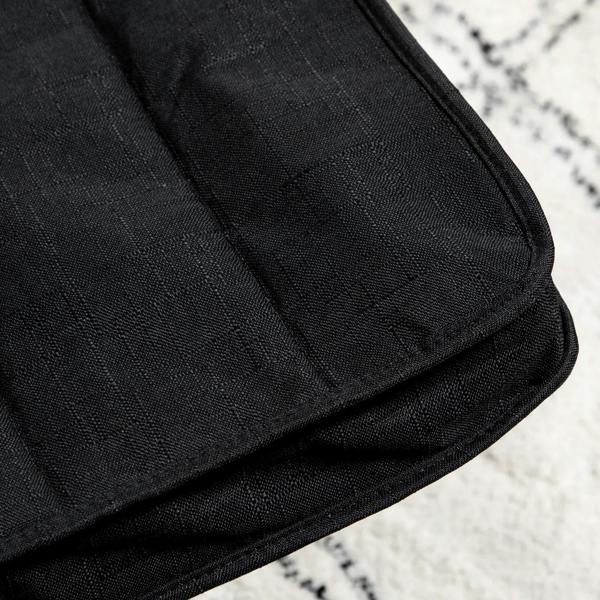 Black linen-textured upholstery fabric on a padded lounge chair seat