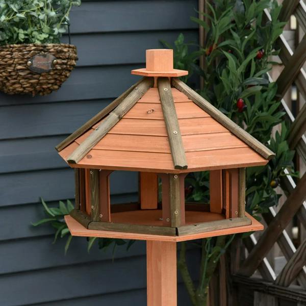 Wooden bird feeding station with hexagonal roof panels and open lower tray
