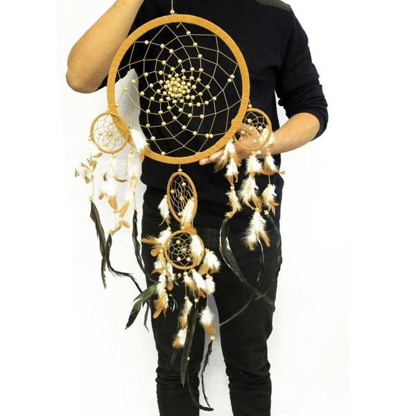 Gold-and-black dreamcatcher with round hoop, feather fringe, and small hanging circles