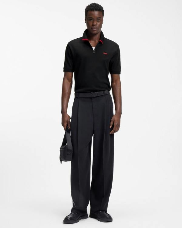 Model wearing HUGO Dalomino Mens Short Sleeve Zip Placket Polo Shirt with Contrast Logo in Black 002 - Full length