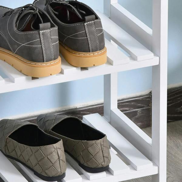 White shoe rack close-up with slatted shelves, holding dark shoes and slippers