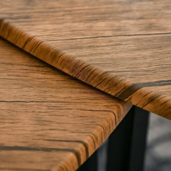 Close-up of walnut wood grain edge detail on tabletop with rounded corner and black legs