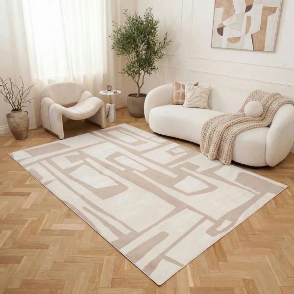 Living room with a geometric patterned rug, white sofa, and decorative plants.