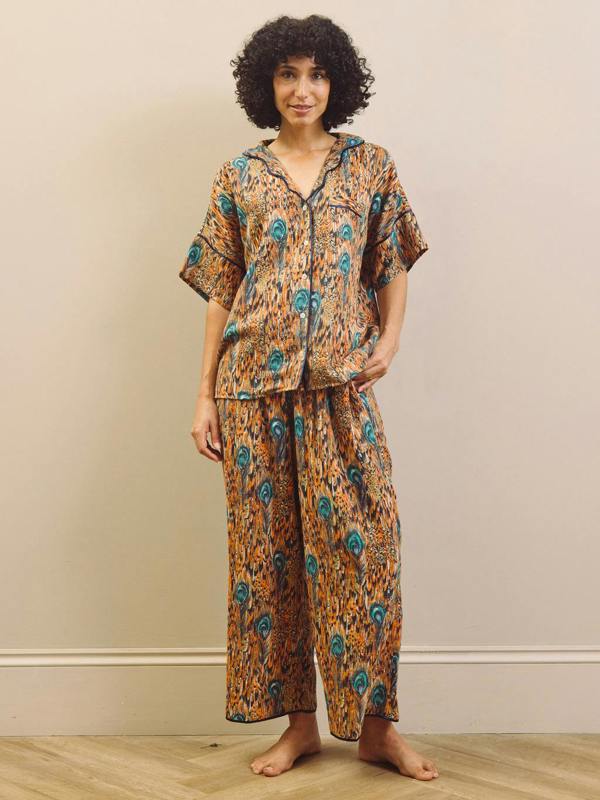 Woman wearing a patterned pyjama set against a plain background