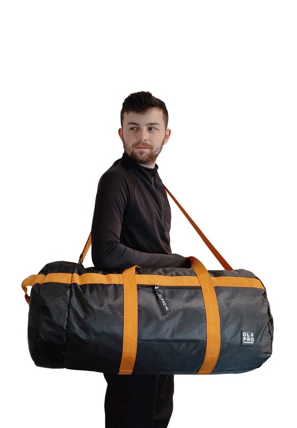 60L Black and Orange Holdall / Duffle Bag OLPRO - man carrying bag on right shoulder