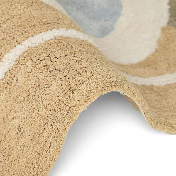 Close-up of a textured beige rug with abstract patterns on a white background