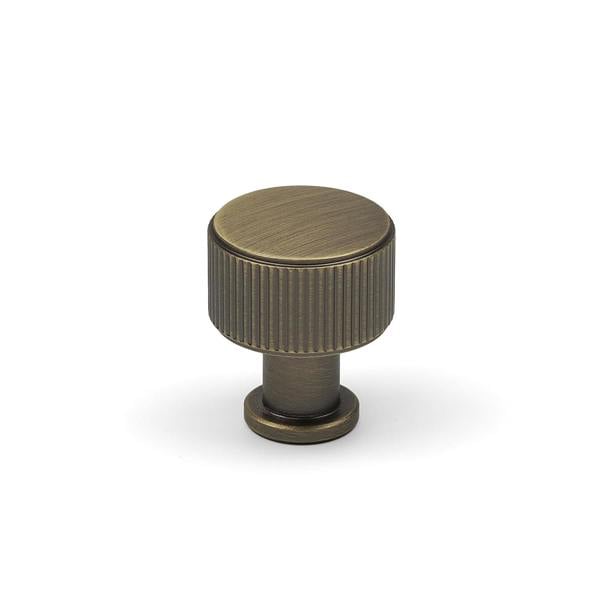 An antique brass reeded round knob