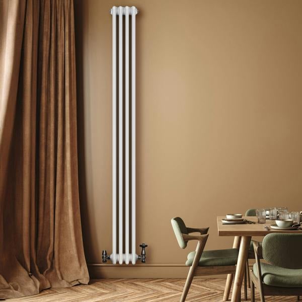 Tall white traditional 4 column radiator with valves, set against a warm beige wall, enhancing a cozy dining area with wooden flooring