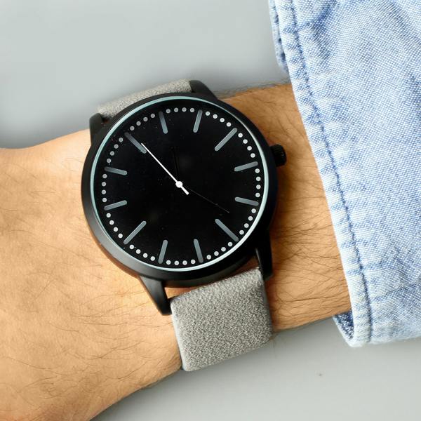 A lifestyle shot of the personalized men's black watch by Abode Home & Gifts being worn on a man's wrist, styled next to the sleeve of a light blue denim shirt.