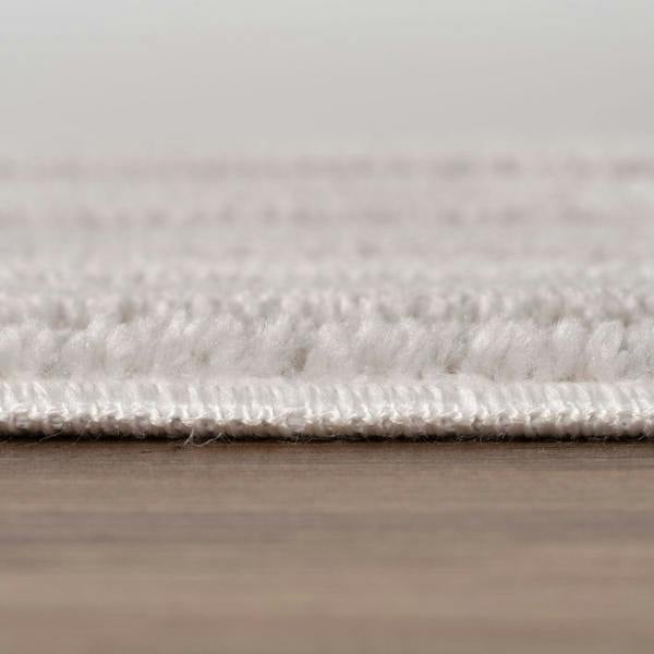 Close-up of a textured rug on a wooden floor