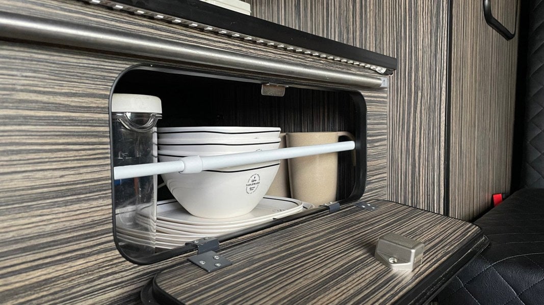 The telescopic cupboard & fridge storage bars being used inside of a VW Campervan from OLPRO