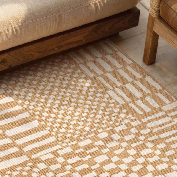 Patterned beige and white rug on a wooden floor with a sofa and chair.