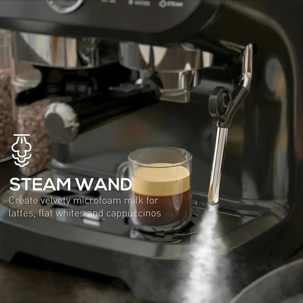 Steam wand releasing microfoam into a cup under a black espresso machine