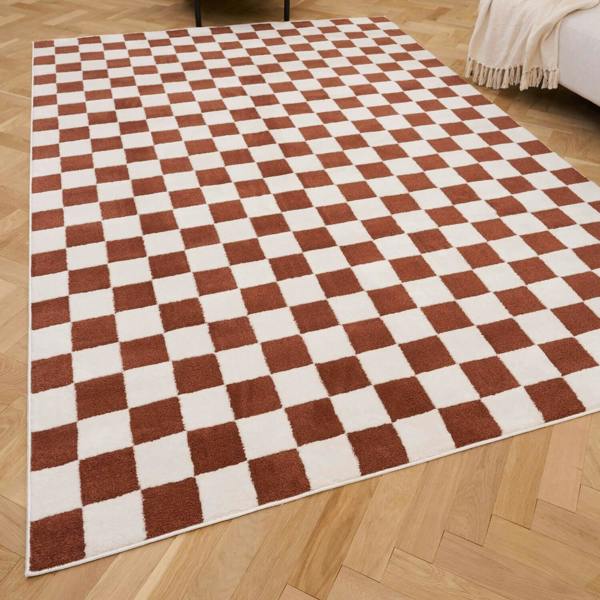 Checkered rug with brown and white squares on a wooden floor