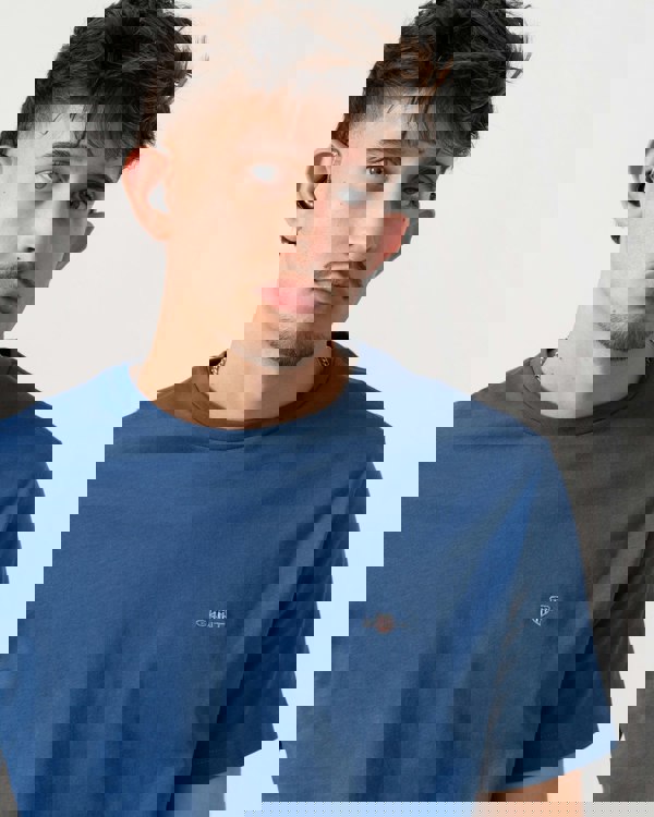 Detail shot of Model wearing a GANT Mens Regular Fit Short Sleeve Shield Logo T-Shirt in Vintage Blue