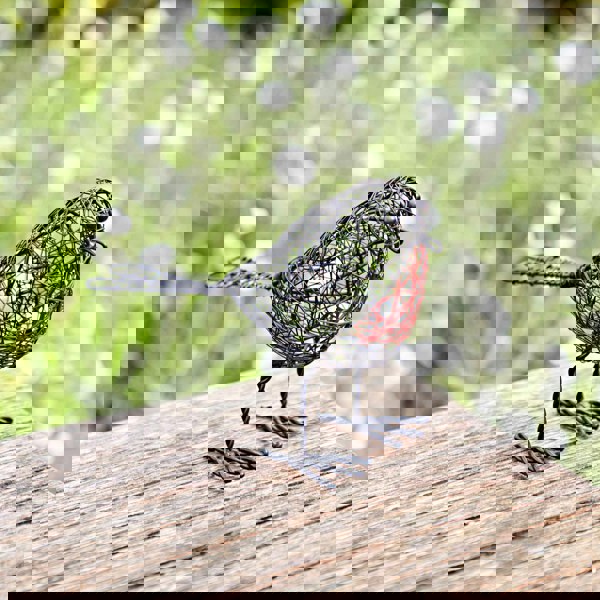 a Set of Two Wire Robin Decorative Ornament sitting on top of a wooden table.