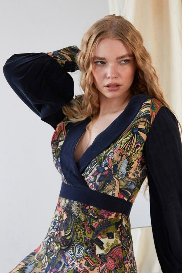 A woman wearing a Sarvin Long Sleeve Mini Dress with a floral print.