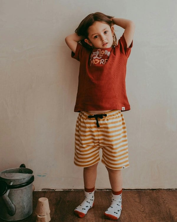 Girl wearing gender-neutral organic cotton kids shorts