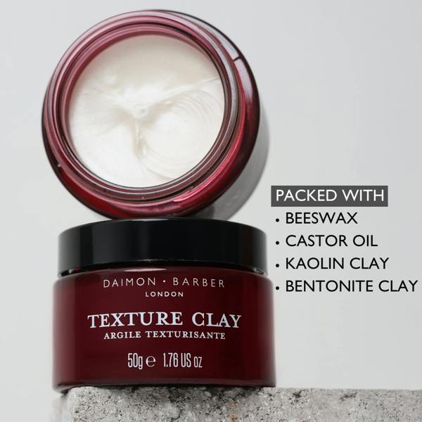 Shot of open Texture Clay on top of closed jar with list of ingredients on grey background