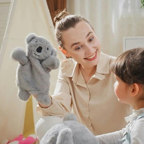 Gray koala plush rocking horse with gloved doll, child and caregiver posing