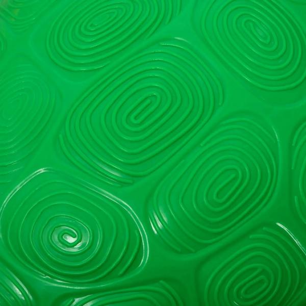 Close-up of green non-slip stepping stone surface with raised swirl pattern