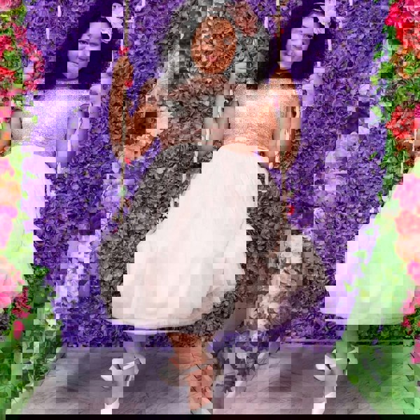 Girl on a swing in a UK Flower Girl party dress