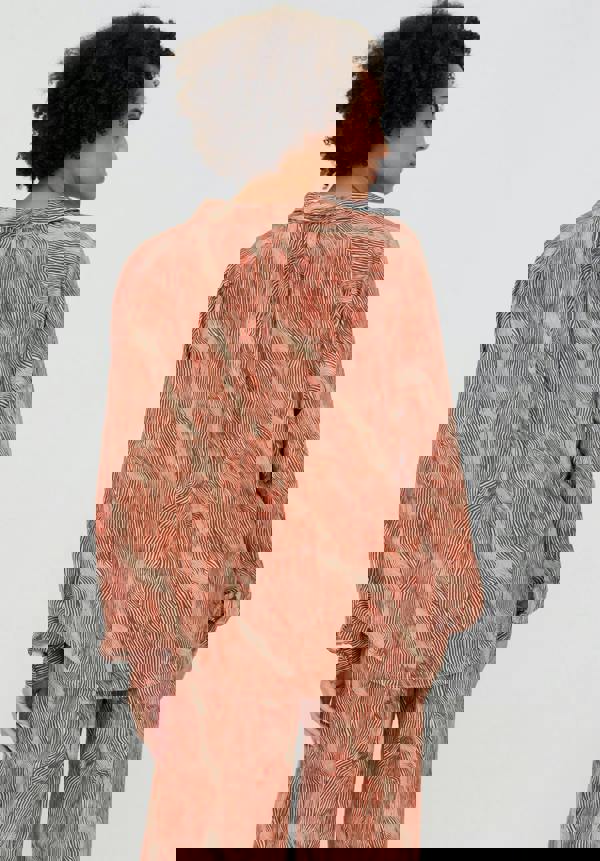 Woman wearing a patterned outfit on a plain background