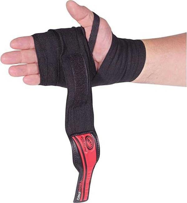Hand wrapped in black Optimum Tech Pro boxing wrap with red logo strap unfastened, on white - Optimum