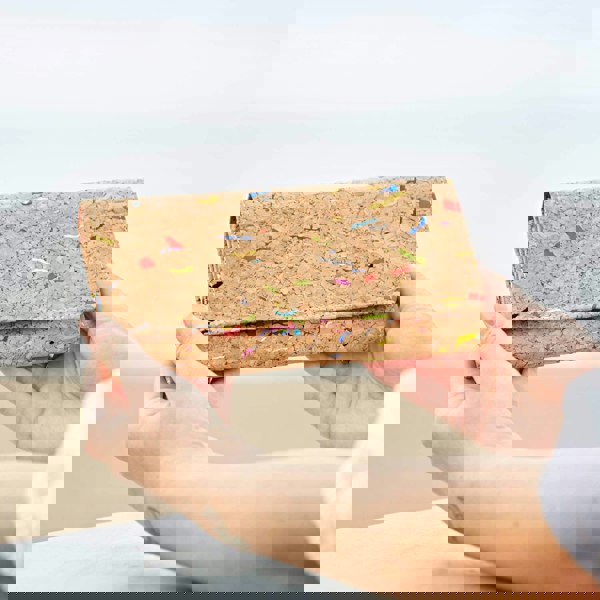 A woman holding up a cork purse.