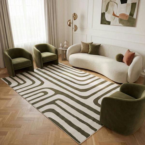 Modern living room with a patterned rug, green chairs, and a white sofa.