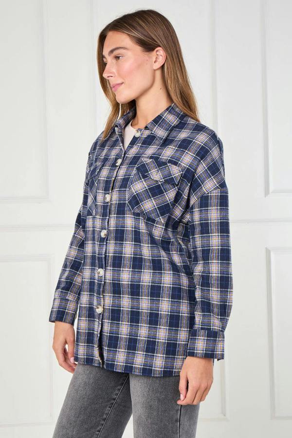 Woman wearing a blue plaid shirt against a white background