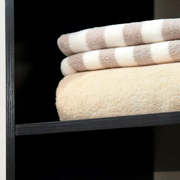 Black open shelf with neatly stacked light-colored towels