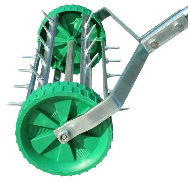Green aerator drum with steel spikes and metal bracket frame attachment