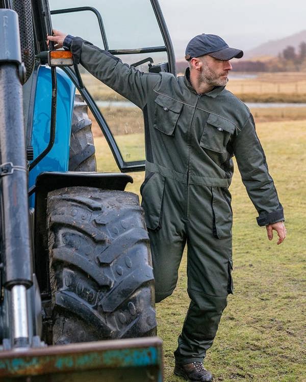 Man climbing out of tractor wearing hoggs of fife workhogg coveralls