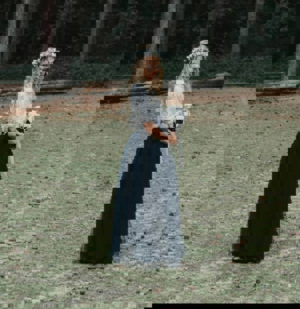 young girl stood in the woods
