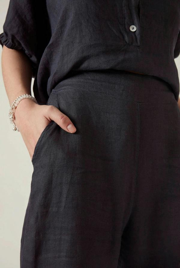 Close up detail of the navy linen fabric and relaxed waistband on the James Lakeland trousers